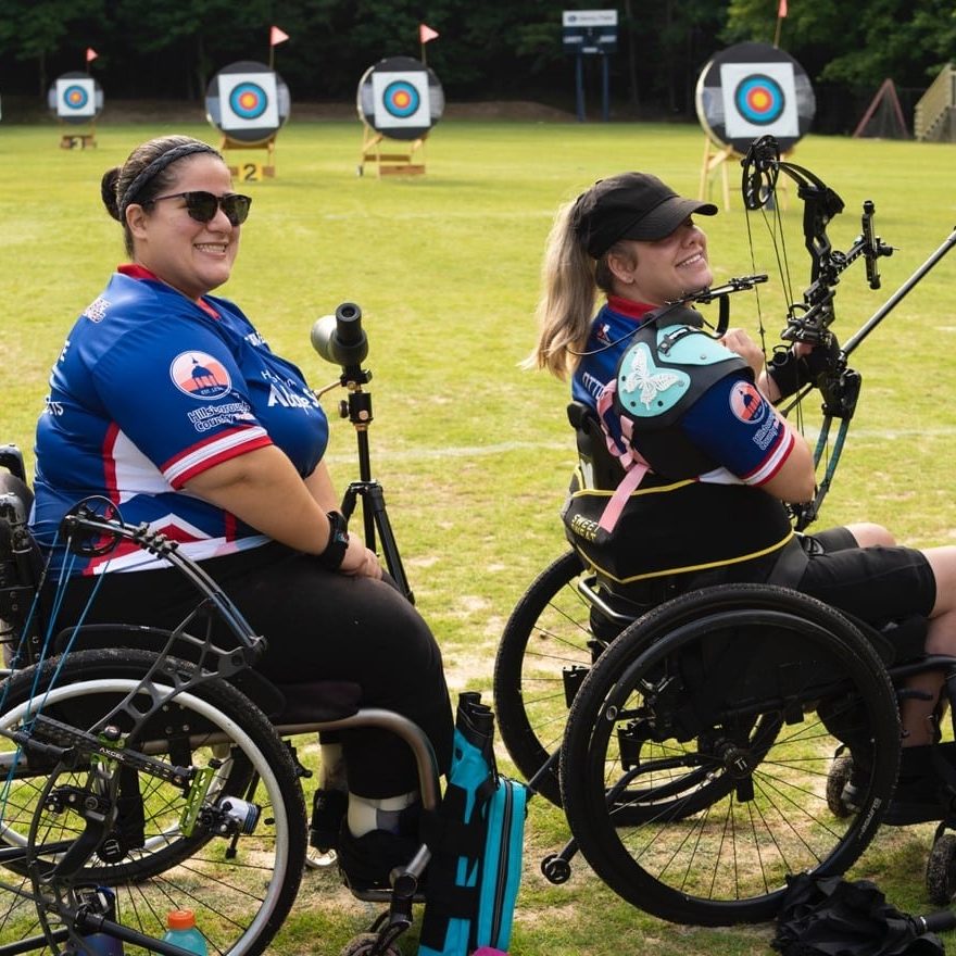 Two adaptive athletes competing in Archery